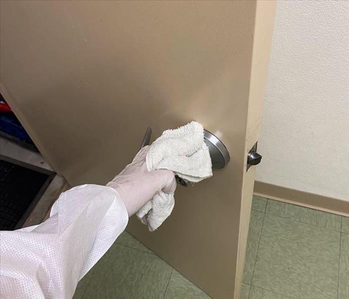man wiping down door handle with rag