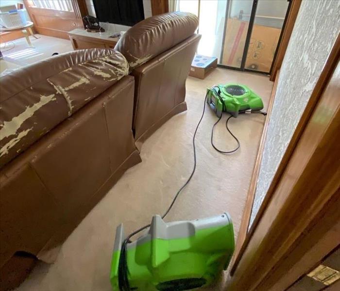 living room with SERVPRO fans drying affected area