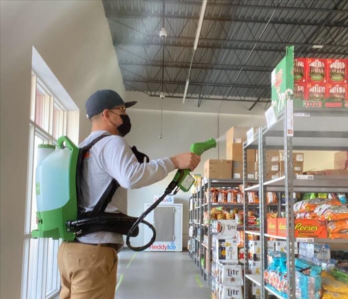 male SERVPRO employee spraying disinfectant 