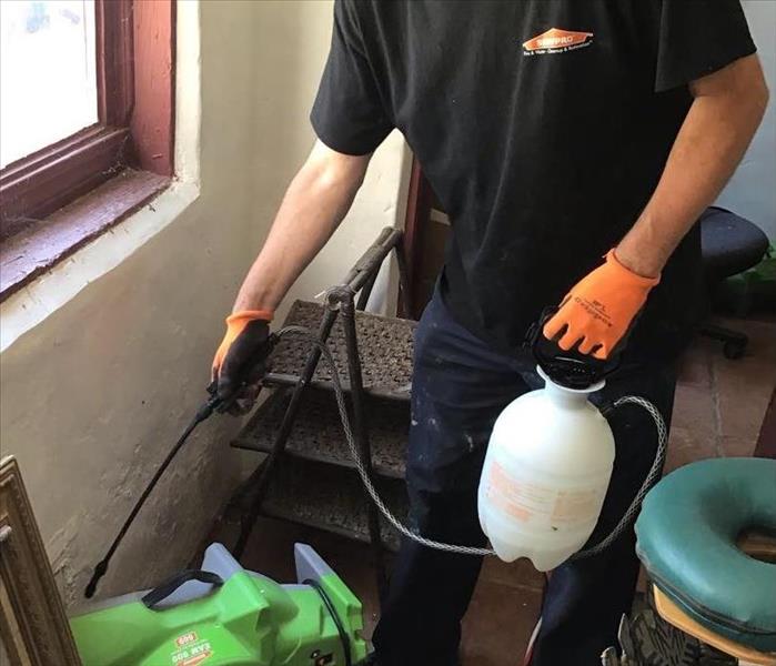 man spraying antimicrobial in home