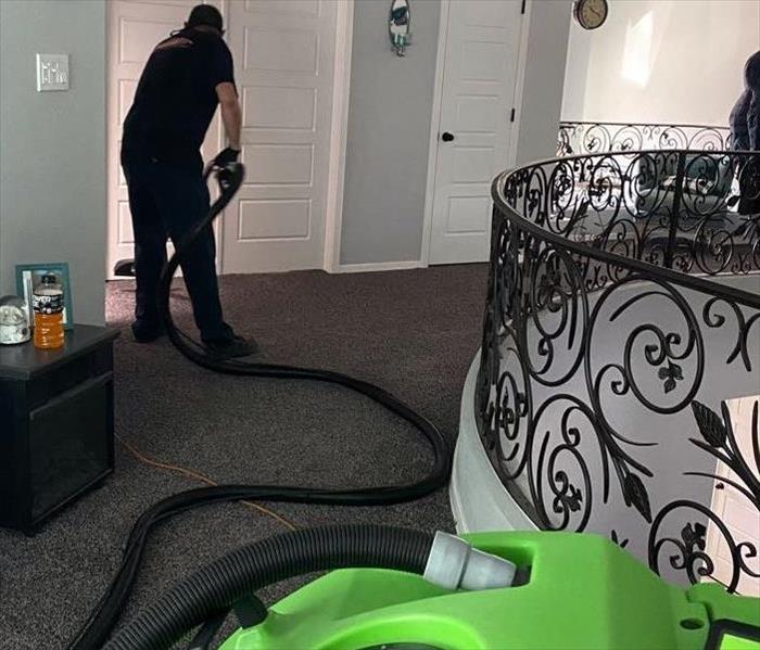 Man vacuuming carpet inside home