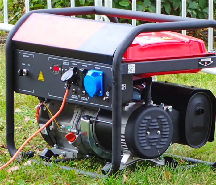 Black and red generator sitting on lawn